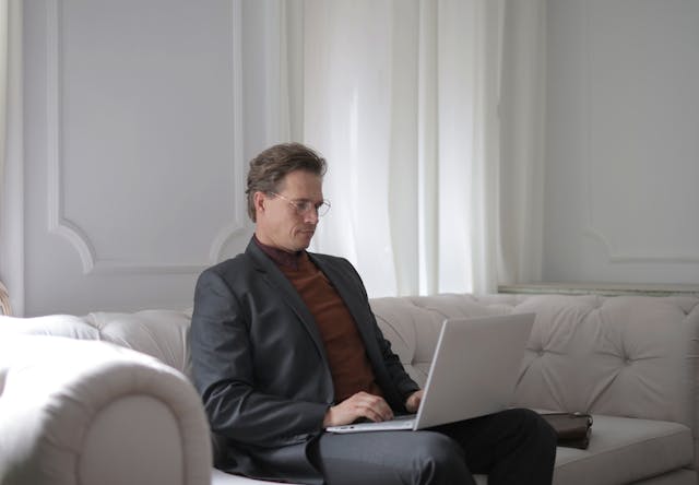 a man sitting behind a laptop - koofr blog